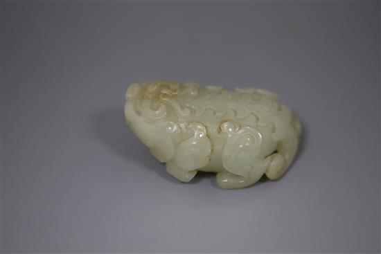 A Chinese pale celadon jade figure of lion-dog, bixi, 17th century, L. 6.8cm, wood stand